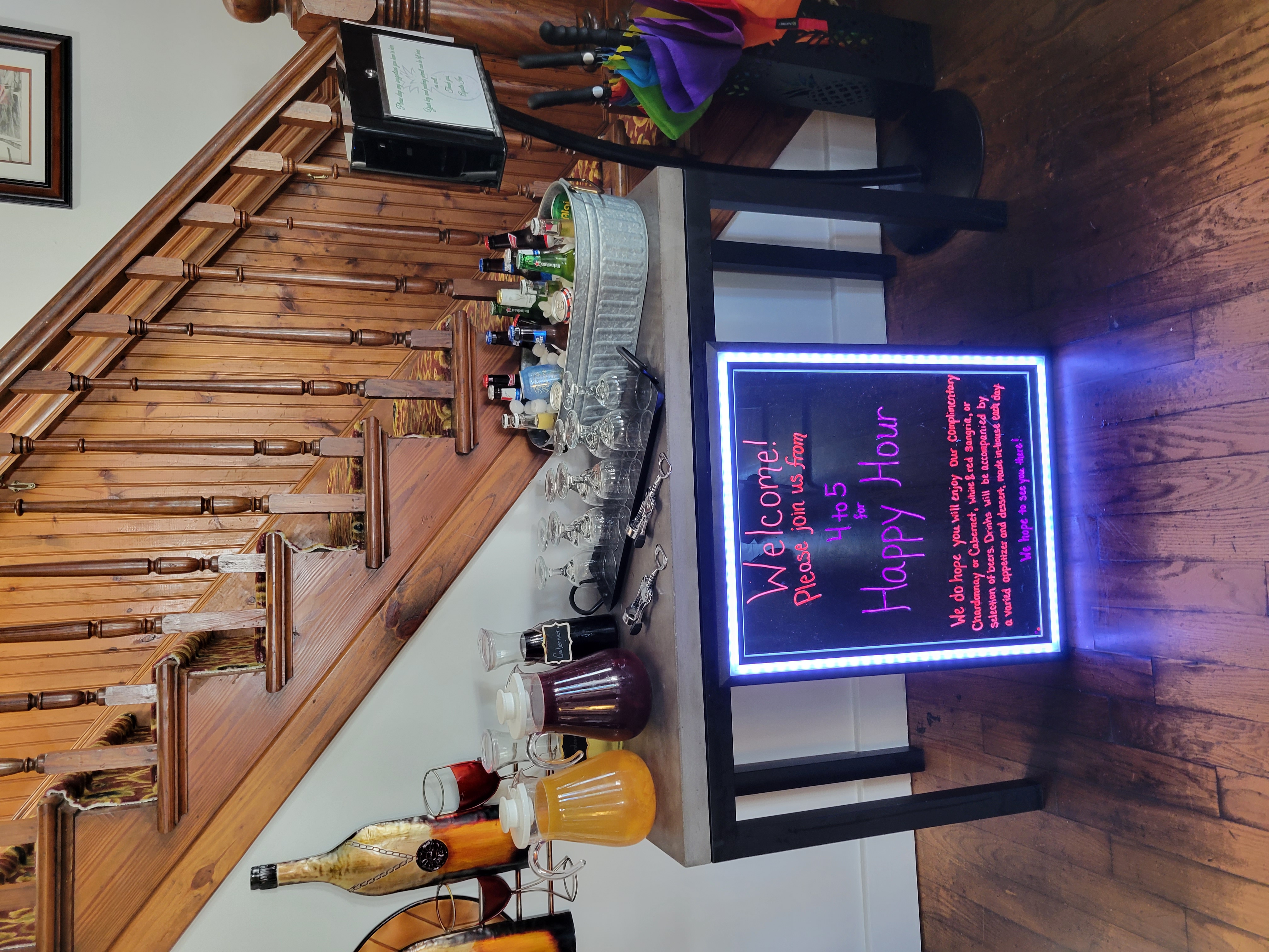 Happy Hour sign with drinks, and a timber staircase in the background