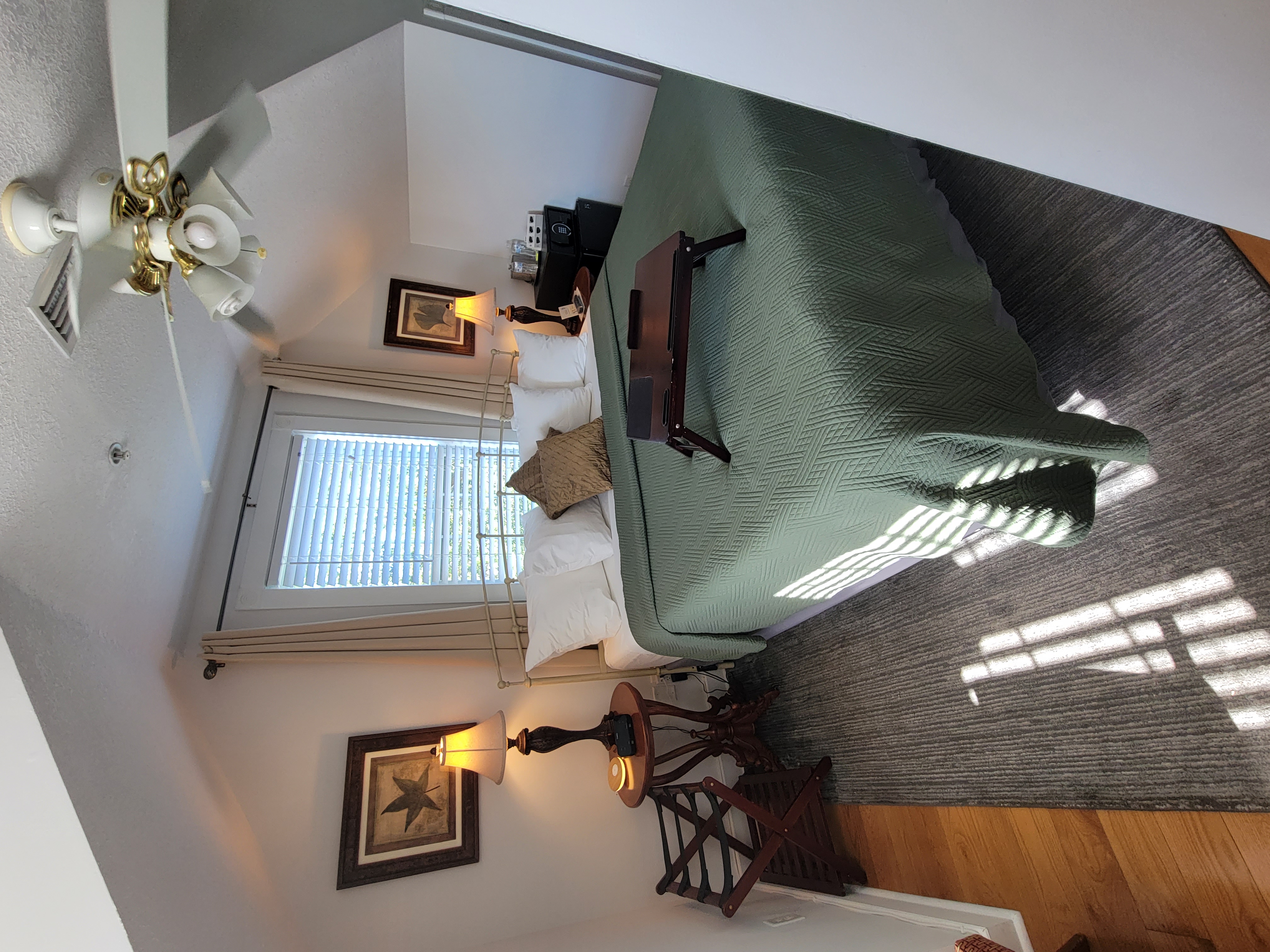 Bedroom with green bed cover and white pillows