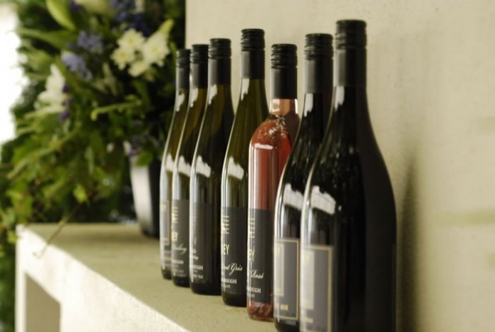 Seven bottles of wine on a shelf at Poppies Vinyard