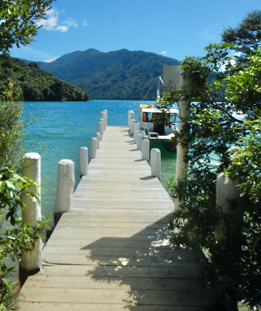 Looking out along a jetty with white posts, out to the Marlborough Sounds New Zealand.