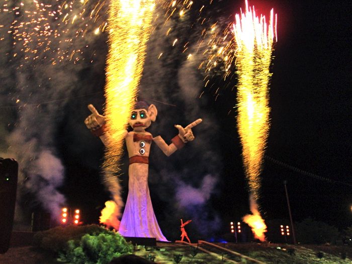 Night time image of fireworks going off beside Zozobra