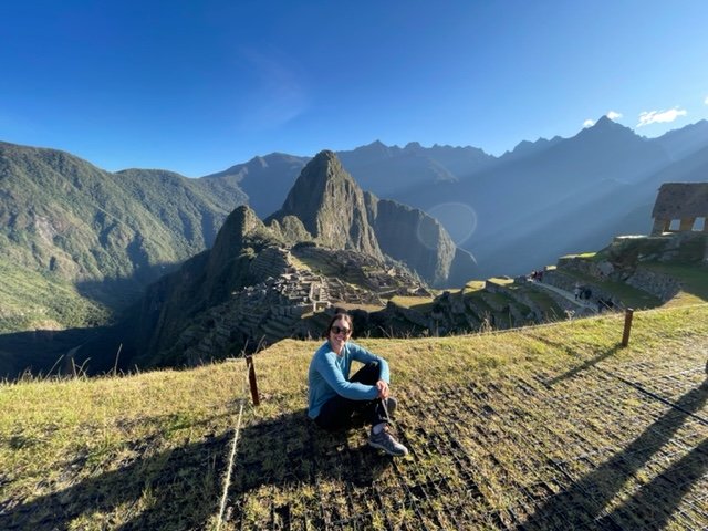 Machu Picchu View - lady overlooking the ruins with a blue sky