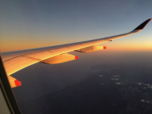 View of an aircraft wing flying at sunset