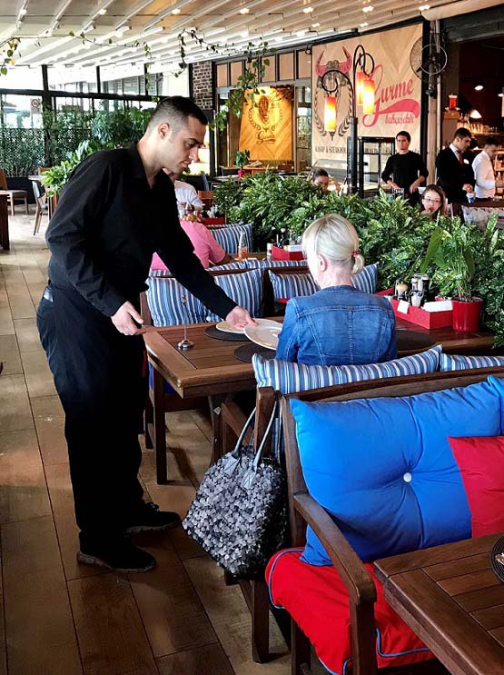 Woman at a restaurant with her bag behind her on the chairback