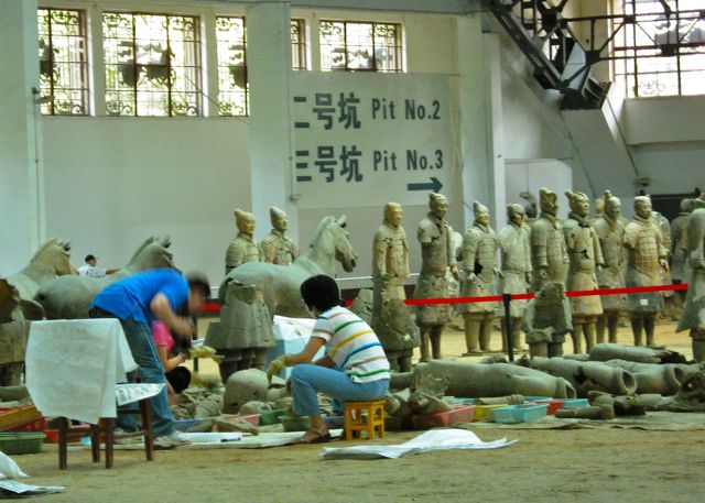 Archeologists working diligently in one of the covered excavation pits in Xian - site of the Terra Cotta warriors