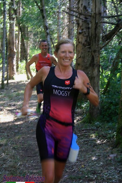 Mogsy and Richard running through woods in triathlon suits on the Bologna swimrun race