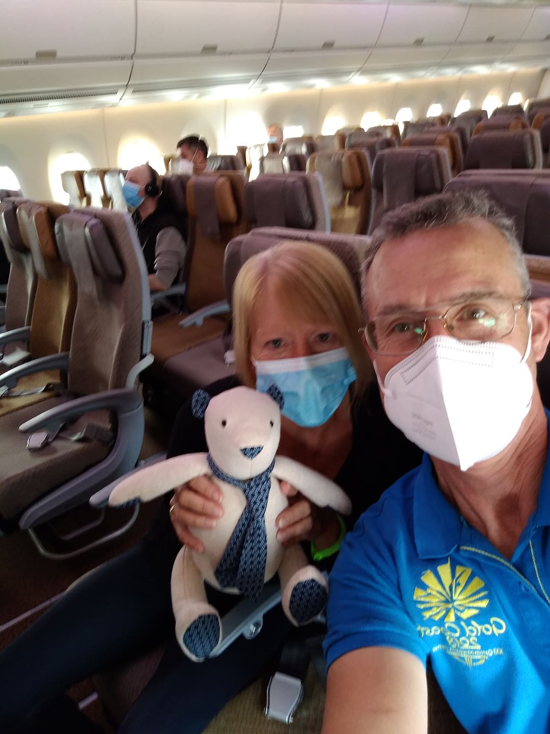 man and woman on plane with a teddy bear