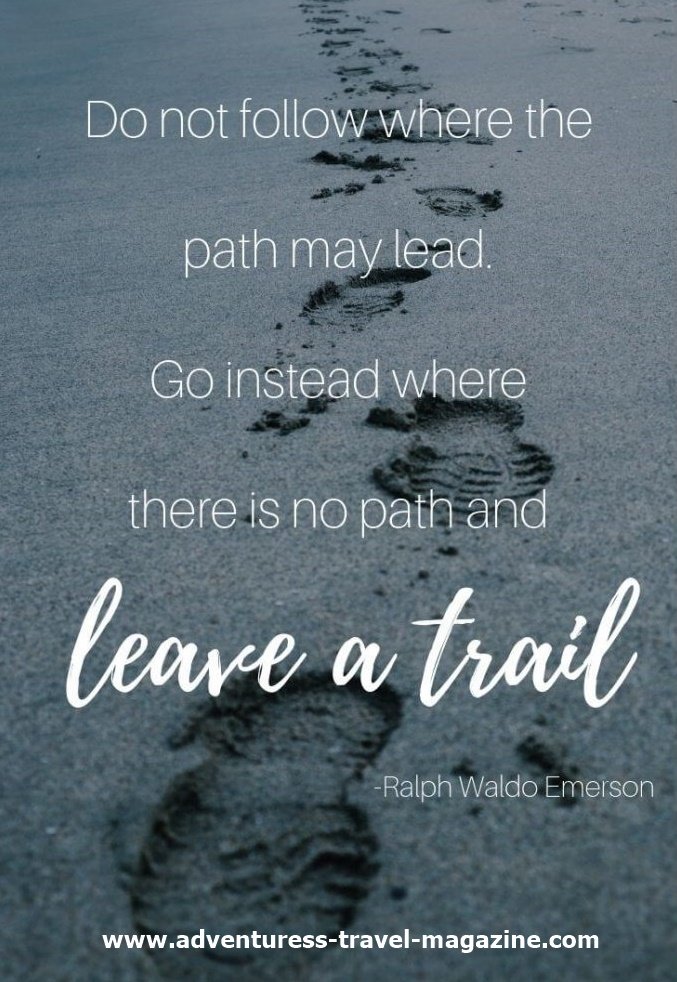 A quote saying "go where there is no path and leave a trail" with footprints in sand on a beach.