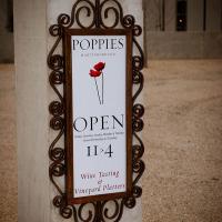 A sign outside Poppies Vinyard advertising wine tasting