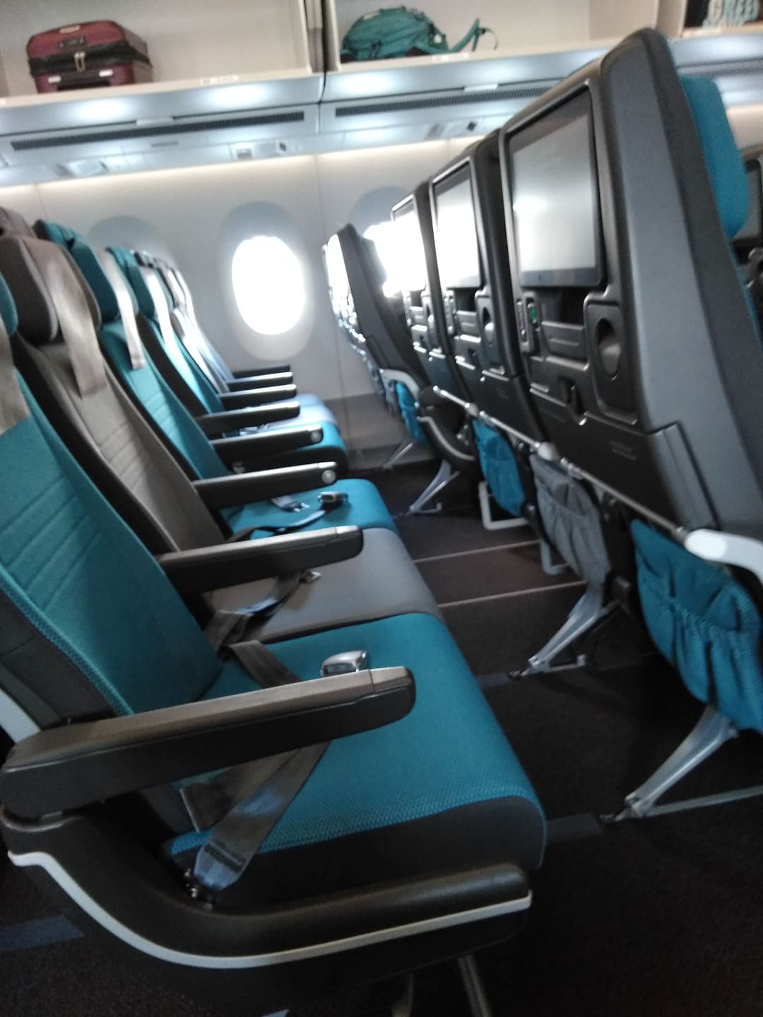 empty row of blue seats on a plane