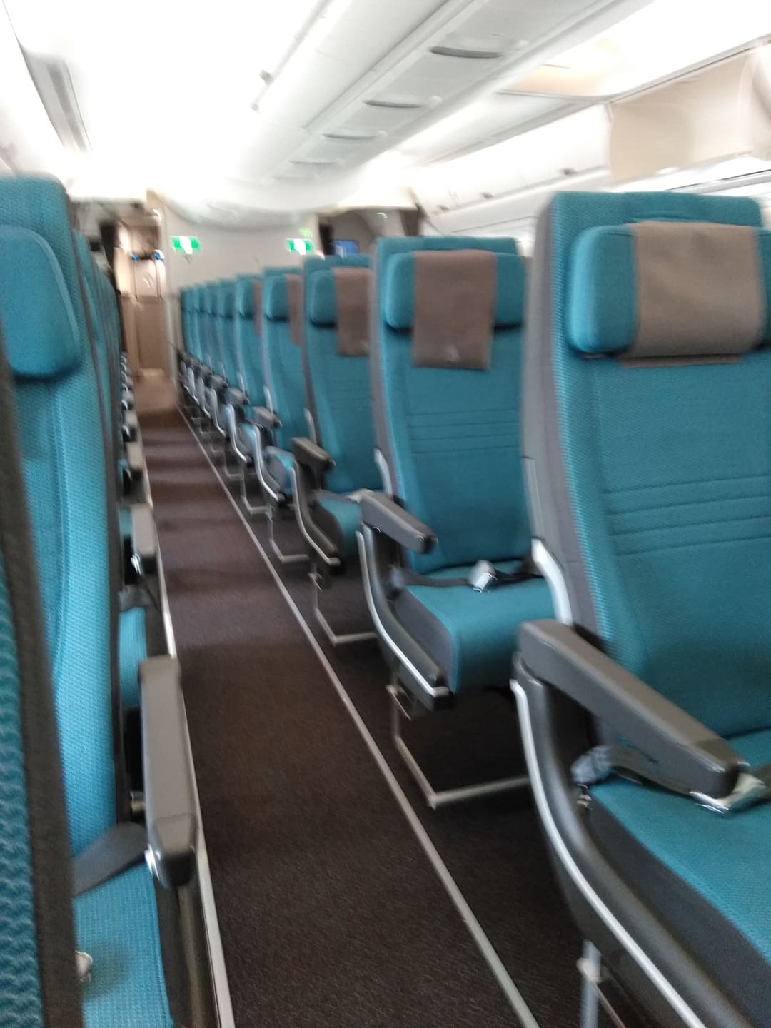 blue seats on a plane and empty aisle